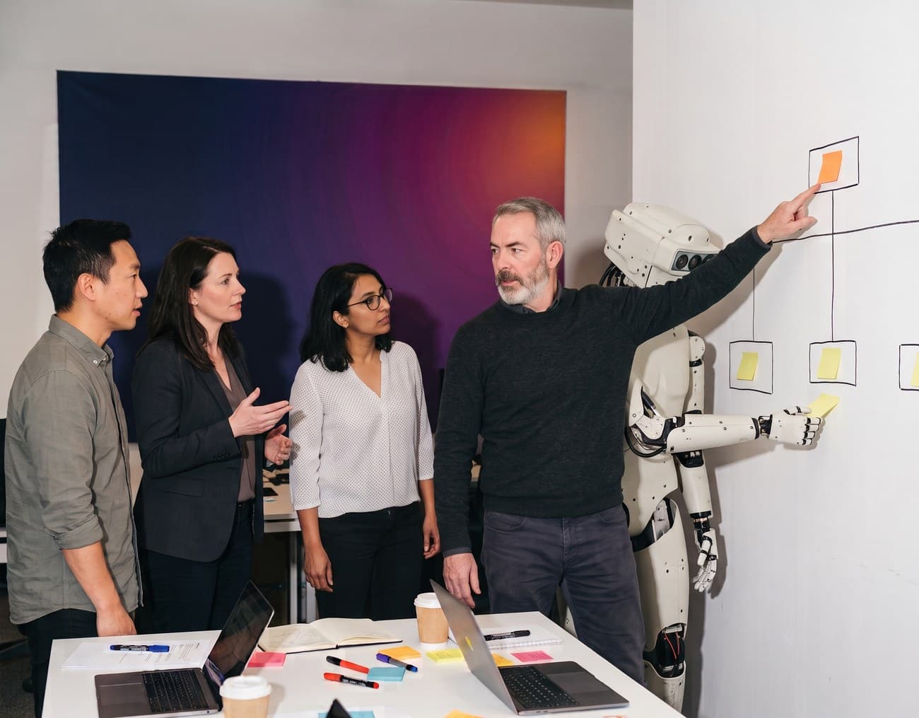 Four colleagues and a humanoid AI agent at a hand-drawn outcome tree; one points at the outcome at the top while the agent adds a sticky note